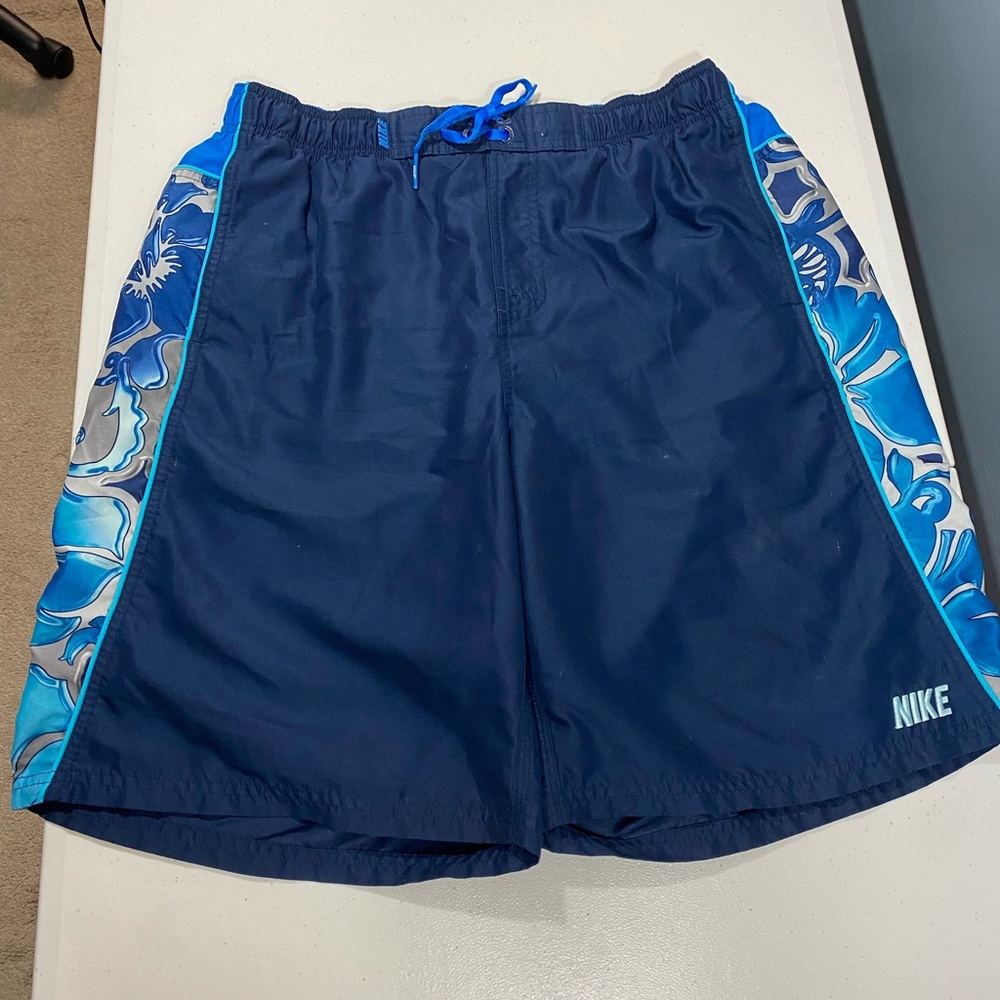 - - Nike size large men's blue swim trunks elastic waist w/side pockets.
